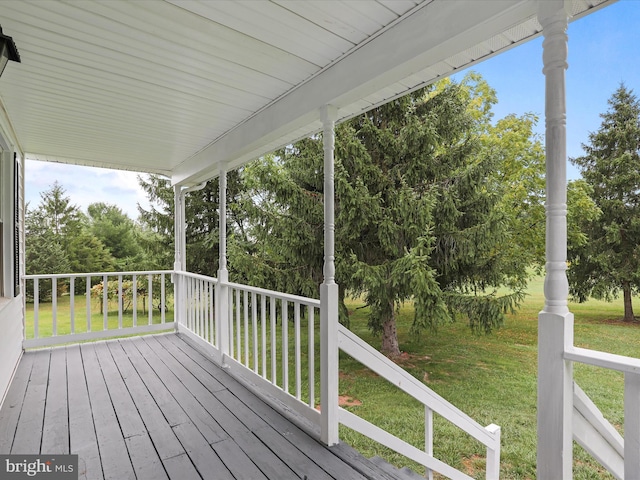 wooden deck featuring a lawn