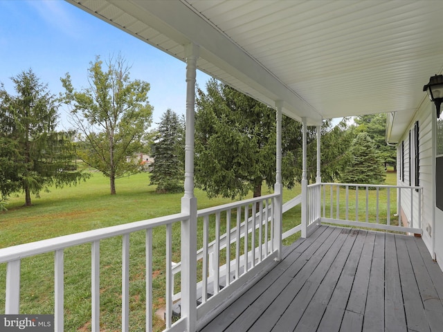 wooden deck with covered porch and a yard