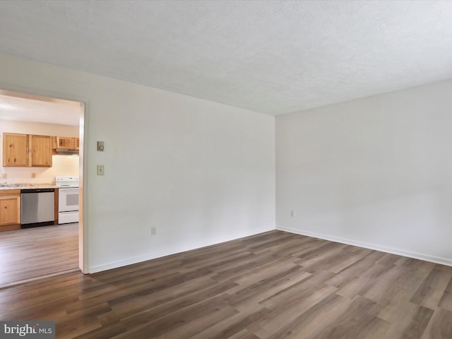 spare room with a textured ceiling and dark hardwood / wood-style floors