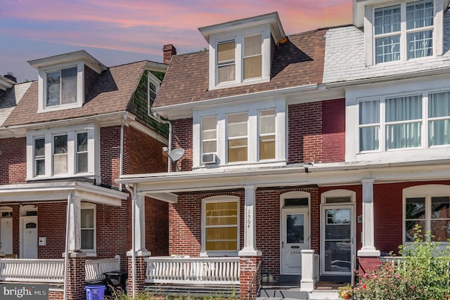 view of front of home with a porch and cooling unit