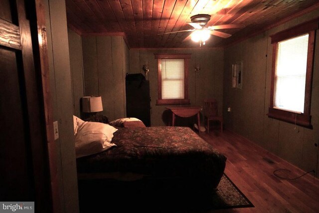 bedroom with wood ceiling, hardwood / wood-style flooring, wooden walls, and ceiling fan