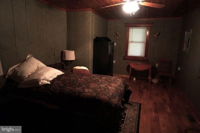 bedroom with ceiling fan, hardwood / wood-style floors, wooden walls, and wooden ceiling