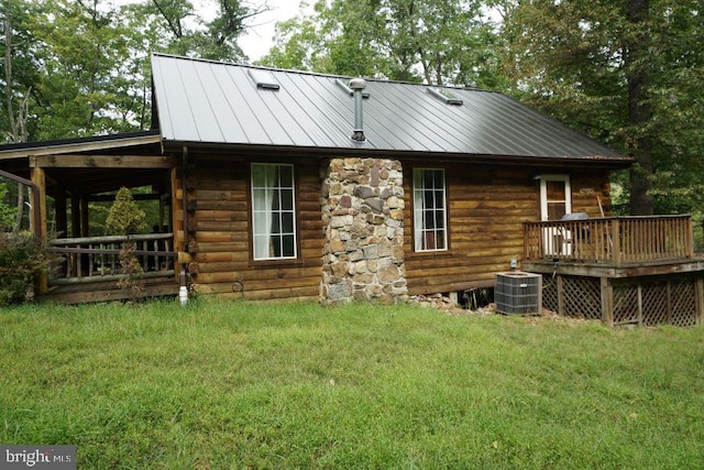 rear view of property with a wooden deck, a lawn, and central AC unit