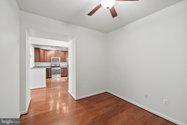 spare room with light wood-type flooring and ceiling fan