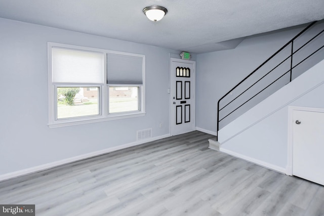 foyer featuring a textured ceiling and light hardwood / wood-style floors