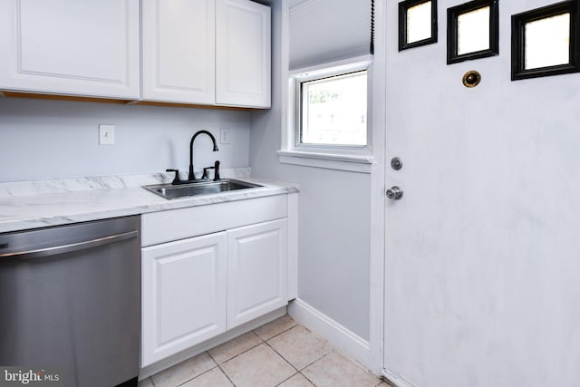 kitchen featuring dishwasher, sink, light tile patterned floors, and white cabinets