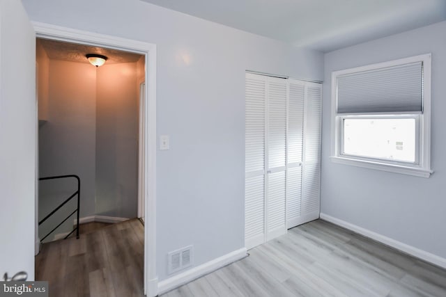 bedroom with hardwood / wood-style floors and a closet