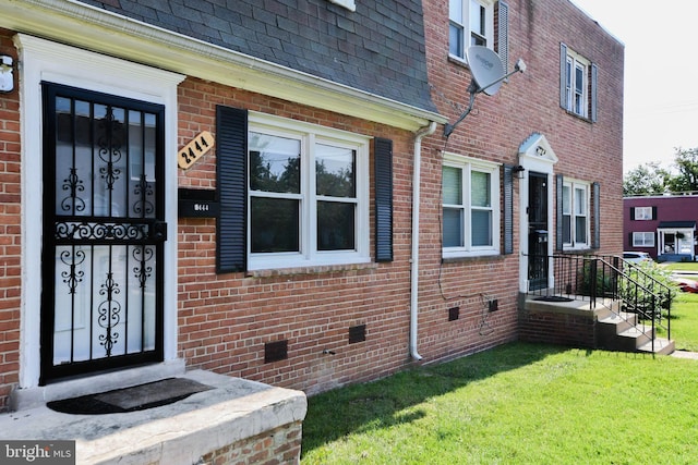 view of exterior entry with a lawn