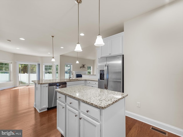 kitchen with a center island, stainless steel appliances, and dark hardwood / wood-style flooring