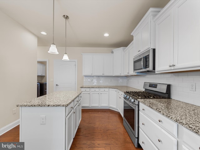 kitchen with a center island, white cabinetry, stainless steel appliances, and dark wood-type flooring