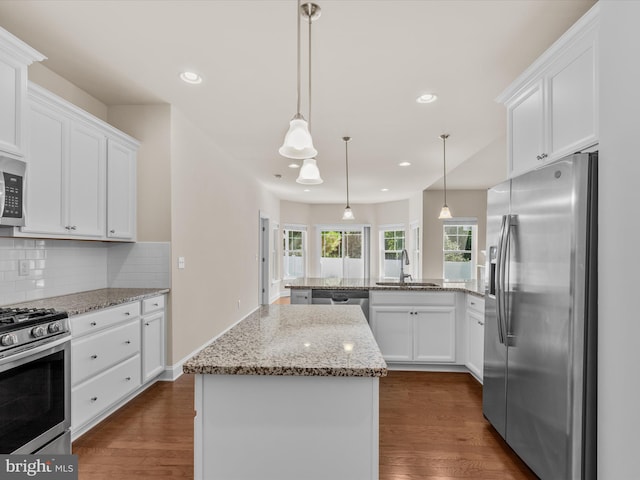 kitchen with a center island, dark hardwood / wood-style floors, appliances with stainless steel finishes, and white cabinetry