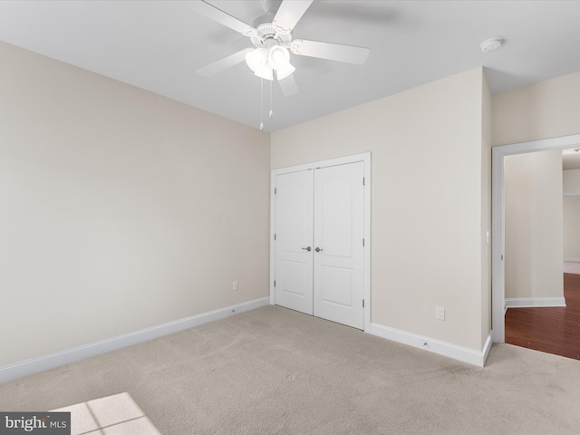 unfurnished bedroom with light colored carpet, ceiling fan, and a closet