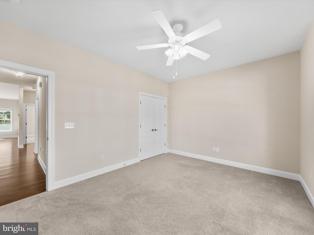 unfurnished bedroom with carpet, ceiling fan, and a closet