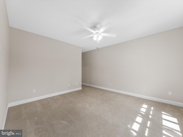 carpeted spare room with ceiling fan