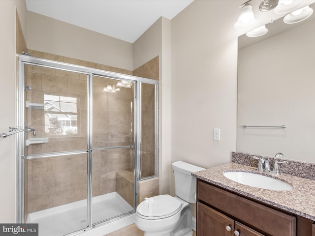 bathroom featuring vanity, toilet, and an enclosed shower