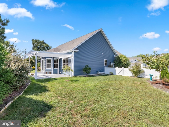 rear view of house with a pergola, a lawn, and a patio