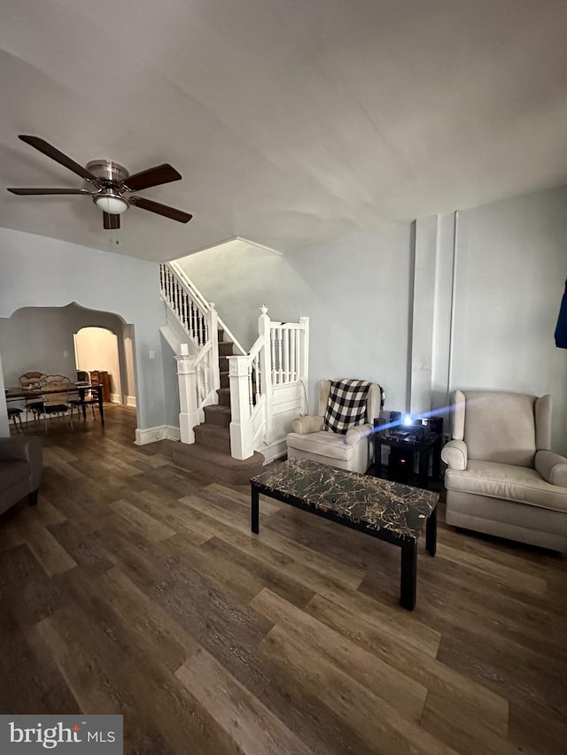 living room featuring ceiling fan and dark hardwood / wood-style floors