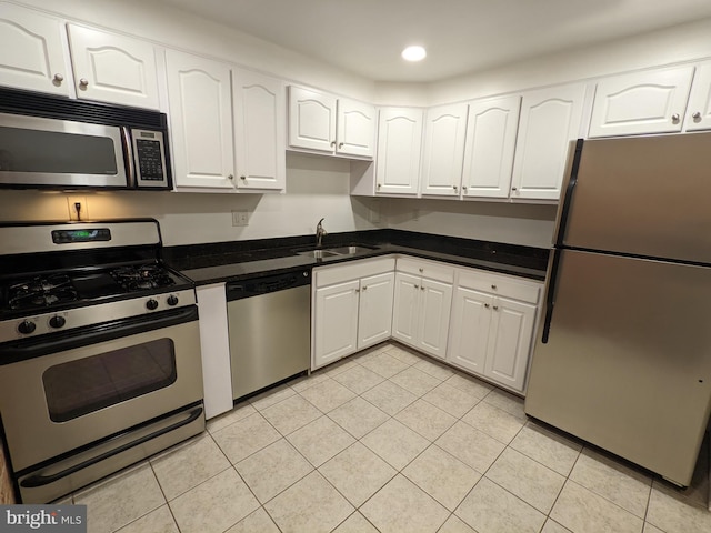 kitchen featuring appliances with stainless steel finishes, white cabinetry, sink, and light tile patterned floors