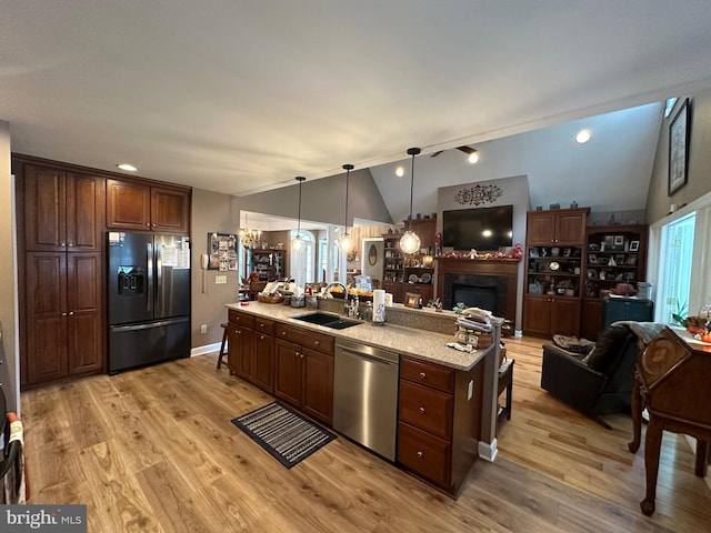 kitchen with dishwasher, vaulted ceiling, refrigerator with ice dispenser, and sink