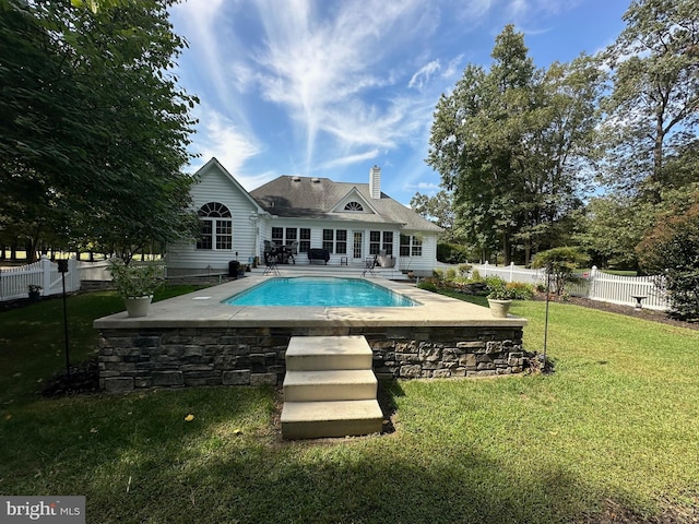 view of pool with a patio area and a lawn