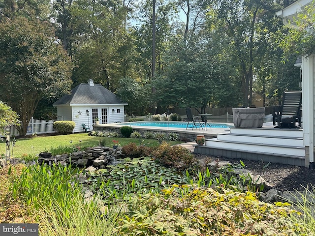 view of yard with a pool side deck and an outdoor structure