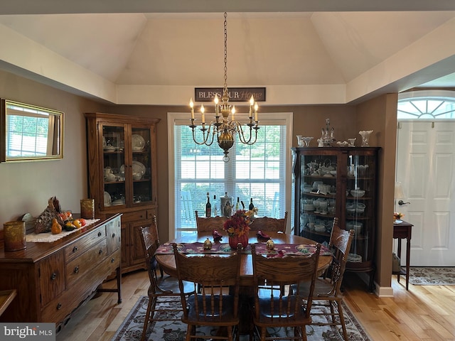 dining area featuring lofted ceiling, a notable chandelier, and light hardwood / wood-style floors