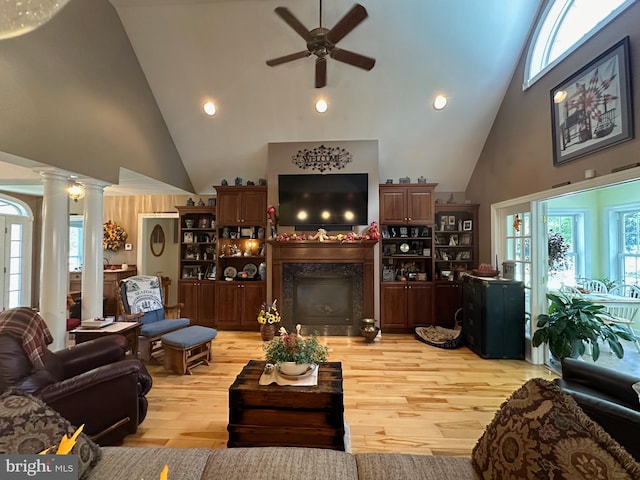 living room with a healthy amount of sunlight, high vaulted ceiling, and light hardwood / wood-style floors