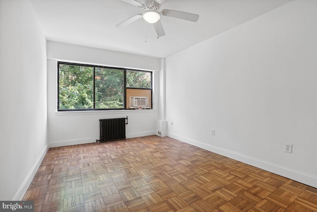 empty room with ceiling fan, radiator, cooling unit, and light parquet floors