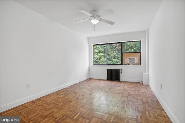 empty room with radiator, ceiling fan, light parquet floors, and cooling unit