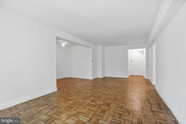 empty room with ceiling fan and parquet flooring