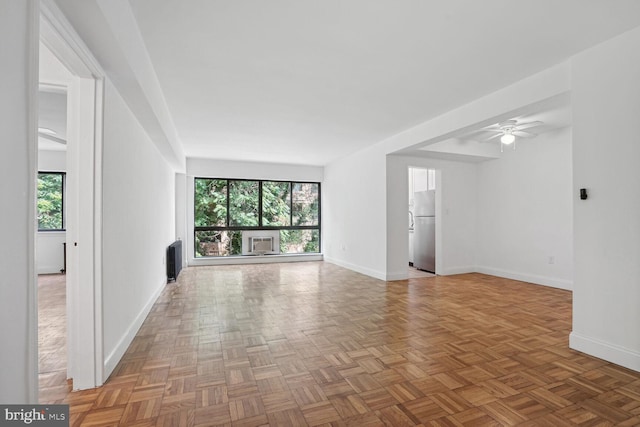 interior space with ceiling fan, parquet floors, and radiator heating unit