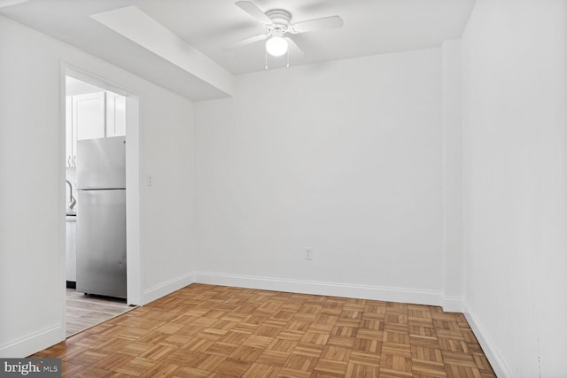 empty room with ceiling fan and light parquet floors