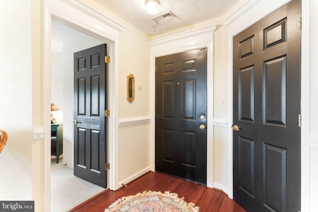 entrance foyer featuring a textured ceiling and dark hardwood / wood-style floors