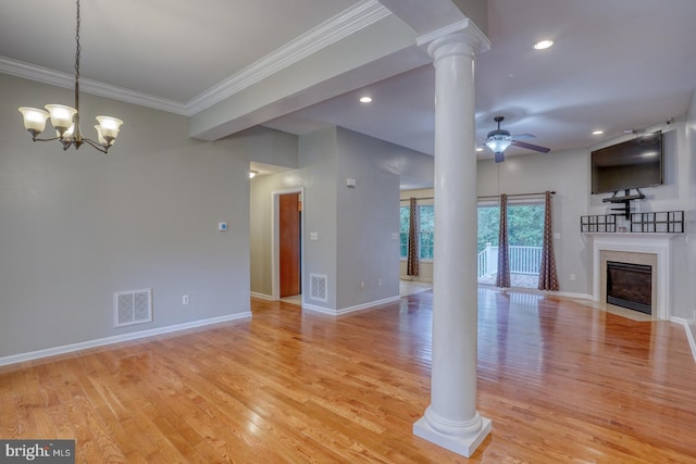 unfurnished living room with light wood-type flooring, ceiling fan with notable chandelier, ornamental molding, and a premium fireplace