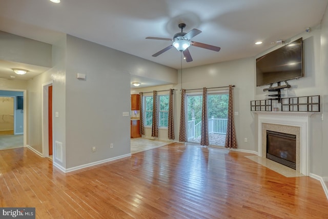 unfurnished living room featuring light hardwood / wood-style floors, a fireplace, and ceiling fan