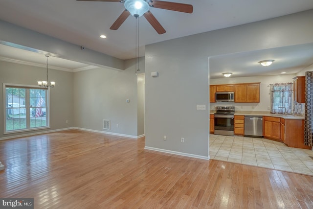 kitchen featuring sink, decorative light fixtures, light hardwood / wood-style flooring, appliances with stainless steel finishes, and ceiling fan with notable chandelier