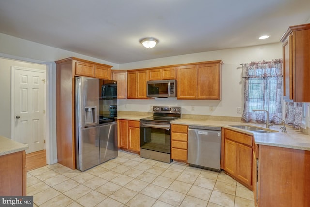 kitchen featuring light tile patterned flooring, appliances with stainless steel finishes, and sink