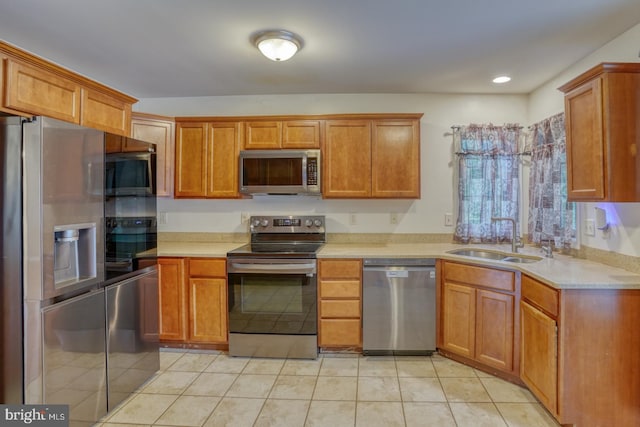 kitchen with light tile patterned flooring, appliances with stainless steel finishes, and sink