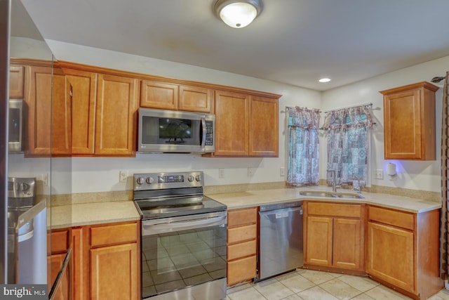 kitchen featuring stainless steel appliances, light tile patterned floors, and sink