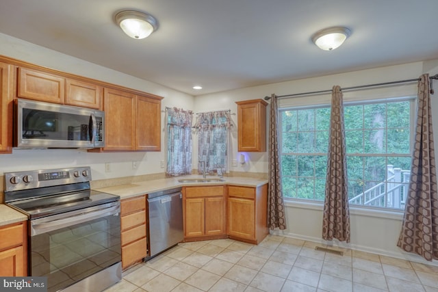 kitchen featuring appliances with stainless steel finishes, sink, and light tile patterned floors