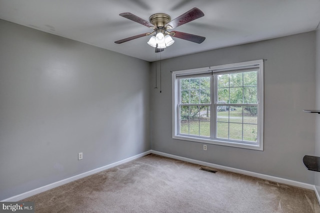 spare room with ceiling fan and light colored carpet