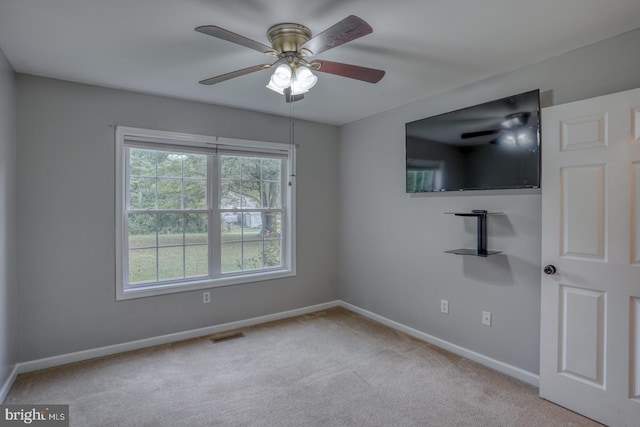 empty room featuring ceiling fan and light colored carpet