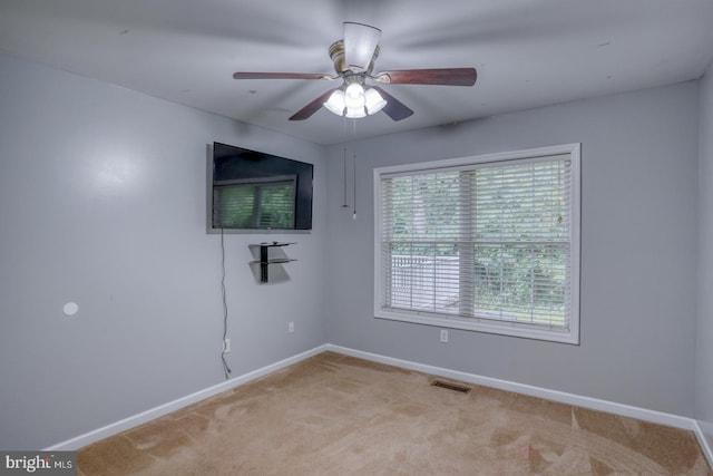 empty room featuring ceiling fan and light carpet