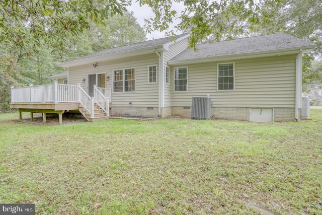 rear view of house featuring a wooden deck, a lawn, and central AC