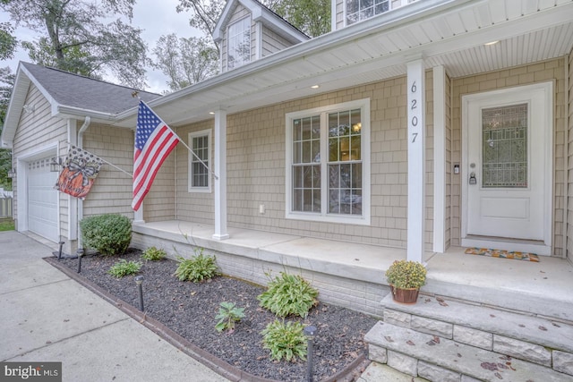 doorway to property featuring a garage and covered porch