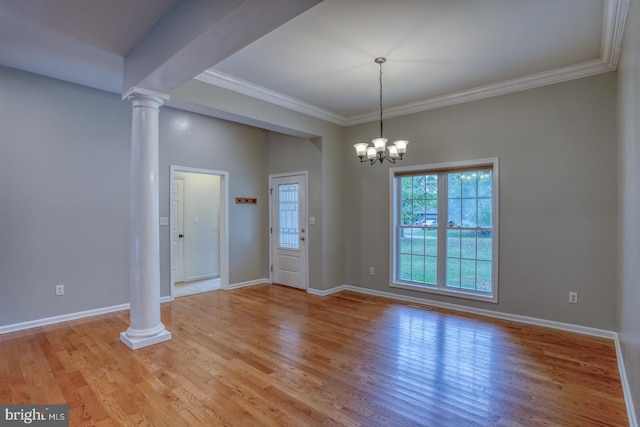 interior space featuring light wood-type flooring, a chandelier, decorative columns, and crown molding