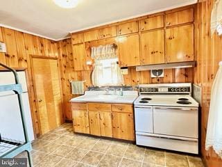 kitchen with electric stove and wood walls