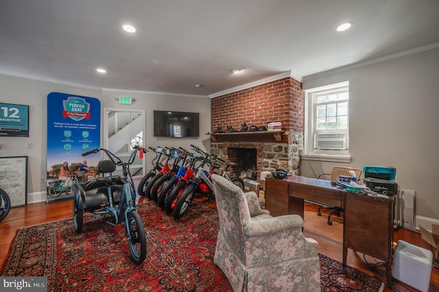 living room featuring a fireplace, ornamental molding, and wood-type flooring