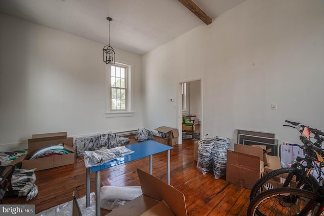 dining space featuring dark wood-type flooring, a baseboard radiator, and vaulted ceiling with beams