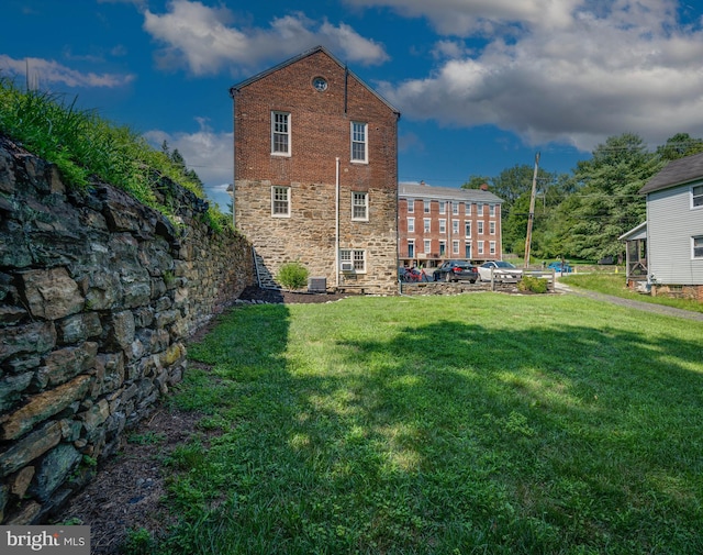 back of property with a yard and central AC unit